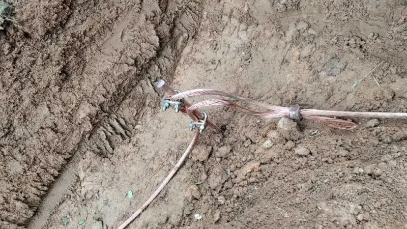 Haste de cobre encravada no solo com cabo de cobre nú conectado na haste com conector tipo "C" para aterramento elétrico.