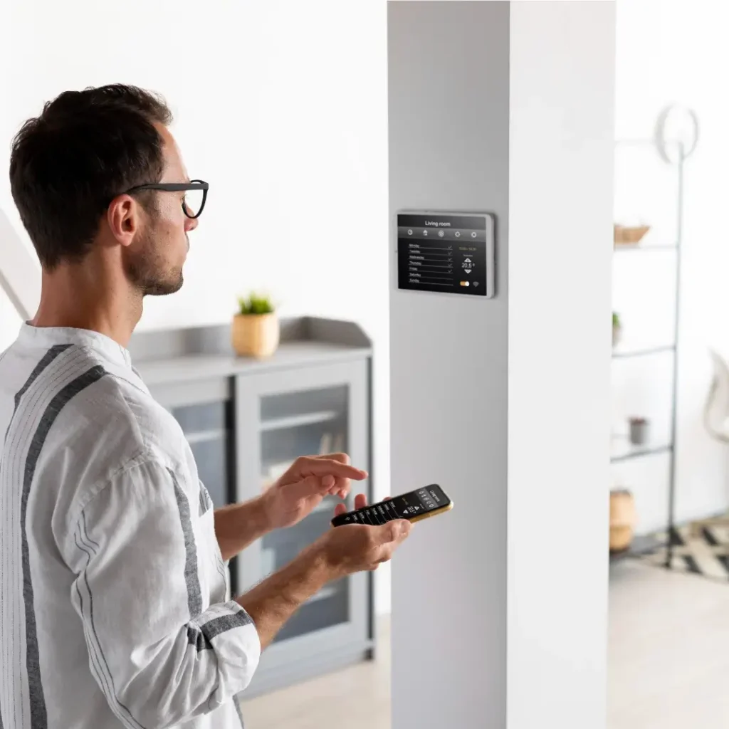 Homem programando central inteligente de alarme de segurança residencial dentro da casa através do celular.