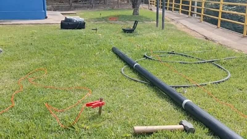 Medição de resistividade do solo para aterramento elétrico: estacas de teste, cabos de medição, marreta e acessórios sobre o gramado — Aplica Engenharia.